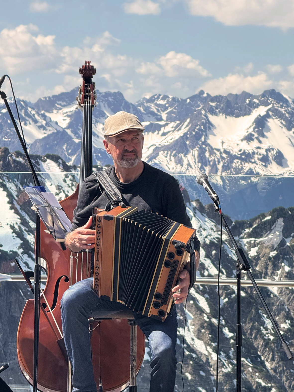 Benno Wechs an der Ziehharmonika während eines Auftritts vor Bergkulisse