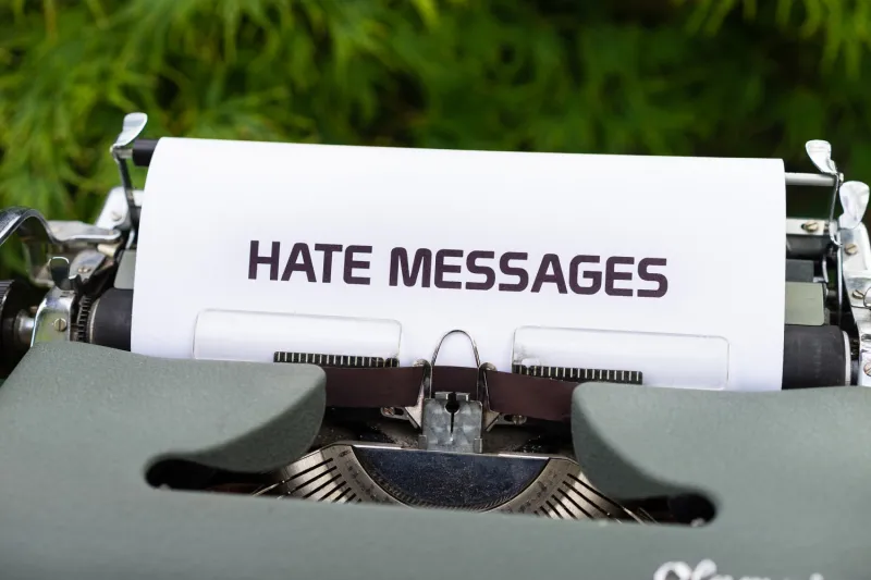 Alte Schreibmaschine, die ein Blatt Papier eingespannt hat, auf dem "Hate Messages" steht.