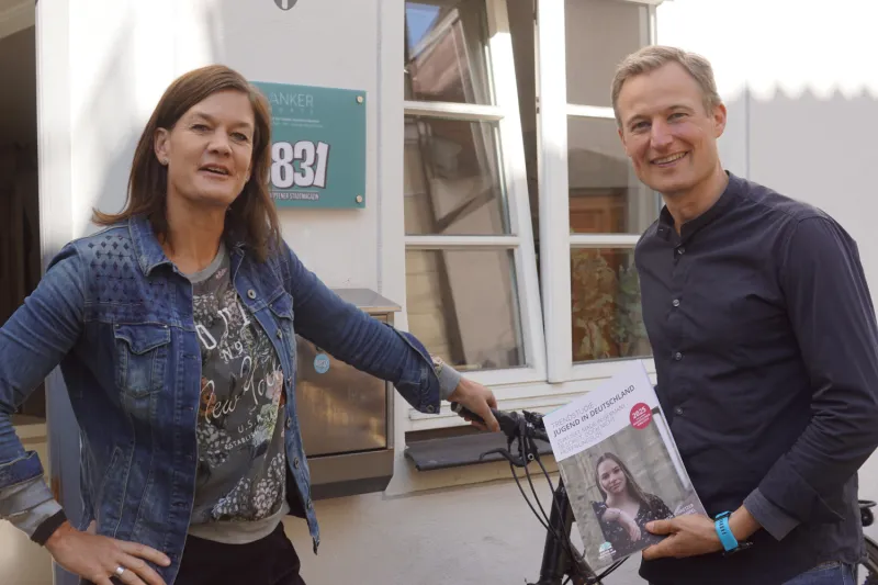 Anke Roser und Simon Schnetzer vor der Tür zum Büro des Stadtmagazins.