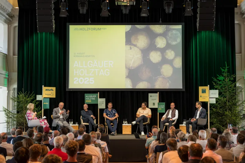 Foto von sitzenden Personen auf der Bühne des Allgäuer Holztages 2025.