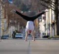 Ein Mann der einen Handstand in der Mitte einer Straße macht