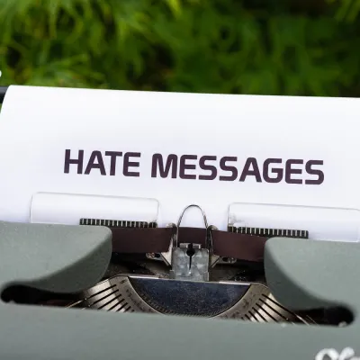 Alte Schreibmaschine, die ein Blatt Papier eingespannt hat, auf dem "Hate Messages" steht.