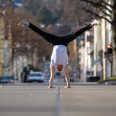 Ein Mann der einen Handstand in der Mitte einer Straße macht