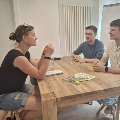 Anke Roser, Inhaberin vom 0831, im Redaktionsbüro im Gespräch mit Dominik Baum und Tobias Stöffel.